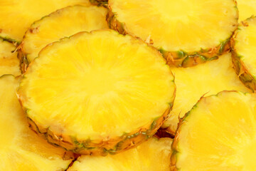 Pineapple juicy yellow slices as a background.