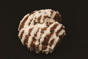 Profiteroles with coconut cream on a black background.