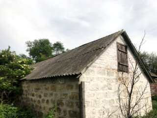 A simple stone structure surrounded by tall grass.