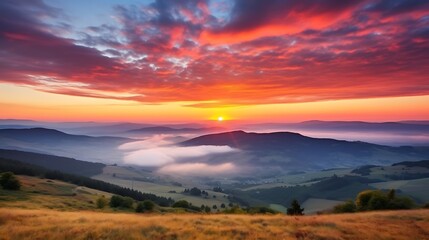 A vivid sunrise with brilliant orange and pink clouds scattered across the sky, the Carpathian ranges in sharp silhouette, sunbeams breaking through the clouds and casting rays across the land.