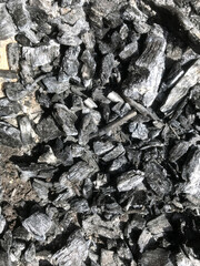Dark charcoal pieces scattered over a textured background.
