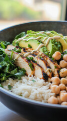 A vibrant breakfast bowl features grilled chicken, fluffy rice, black beans, fresh greens, corn, tomatoes, and avocado, served in a charming cafe setting