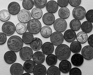 A monochrome pattern image featuring scattered coins covering the entire frame. The coins have a...
