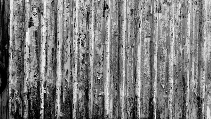 The corrugated metal surface is black and white, and the metal looks like it’s covered in layers of old posters, stickers, and advertisements that have been torn apart over time, leaving a jumbl
