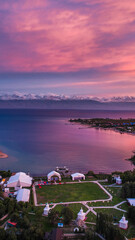 Breathtaking aerial view of Issyk Kul Lake at sunset, showcasing vibrant pink and purple skies over...