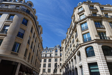 The facade of traditional French house with typical balconies and windows. Paris, France.