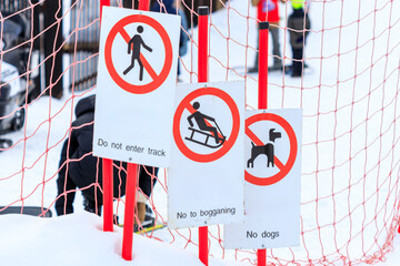 Three signs are posted on a fence, warning people not to enter the area