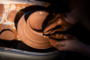 A person is making a pottery piece with their hands