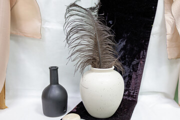 A black vase and a white vase are on a table
