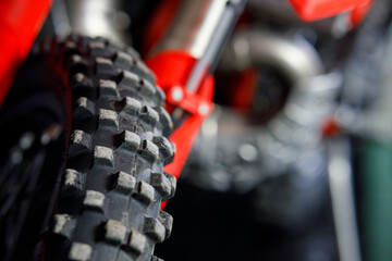 A close up of a red dirt bike tire with black tread