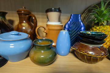 A collection of vases and cups on a shelf