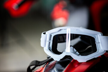 A pair of goggles sits on a red surface