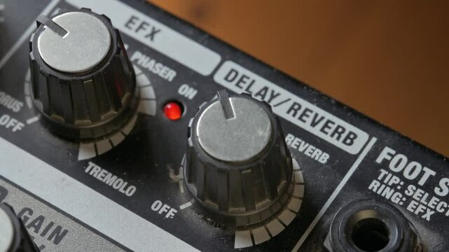 Man tuning volume and gain knobs on guitar amplifier. 4k video footage UHD 3840x2160