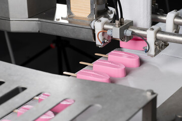 Close-Up of Pink Ice Cream Popsicles on Industrial Production Line – Frozen Dessert Manufacturing