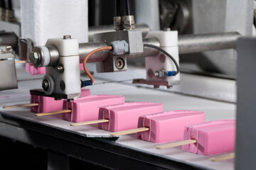 Close-Up of Pink Ice Cream Popsicles on Industrial Production Line – Frozen Dessert Manufacturing