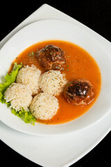 Traditional roasted meatballs with rice and tomato sauce