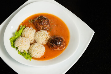 Traditional roasted meatballs with rice and tomato sauce