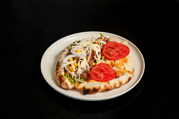 Beef sandwich with onion, lettuce, corn, tomato and cheese