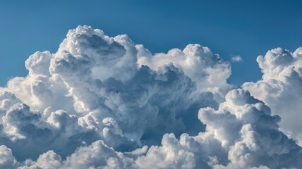 A close-up view of fluffy, white cumulus clouds against a clear, bright blue sky.