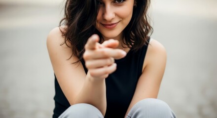  Woman with dark hair pointing finger at camera. Female making hand gesture of choice, idea. Portrait style.