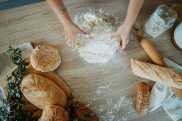 Young caucasian woman making bread dough with rolling pin and flour
