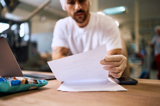 Close up of production facility worker going through paperwork.
