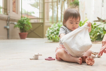 Toddler explores cloth bag and toys during quiet playtime in Barcelona greenhouse