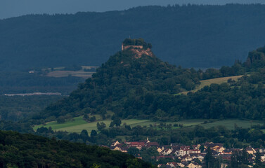 Panoramic view of a scenic hillside with a historical castle perched atop, surrounded by lush...