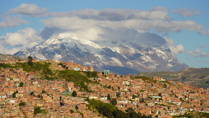 Aerial views of La Paz, Bolivia featuring the cable car system, city sprawl, and majestic snow-capped Andes mountains in the background.