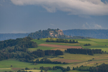 Rolling green hills with a distant castle and dramatic sky captured in late afternoon