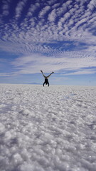 Handstand photo over the Uyuni Salt Flats in Bolivia, endless white landscapes under a vast blue sky