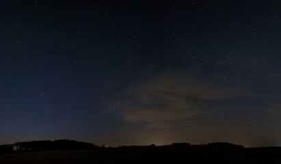 Landschaftsaufnahme von leuchteten Nachtwolken und Sternenhimmel.