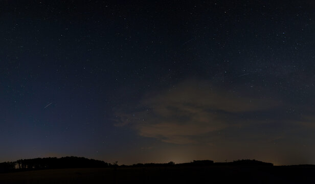 Landschaftsaufnahme von leuchteten Nachtwolken und Sternenhimmel.