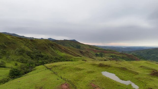Aerial view of highland fields with hills, puddles and hikers under a cloudy sky in Ng&auml;be-Bugl&eacute;, Panama