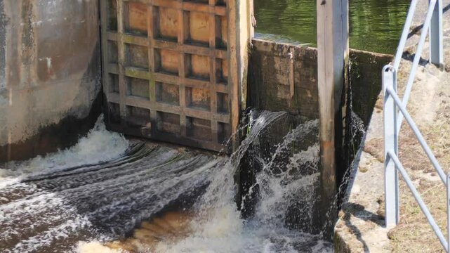 Mighty Flow: Water Rushing Through an Open Sluice Gate, Potentially Breaching a Dam
