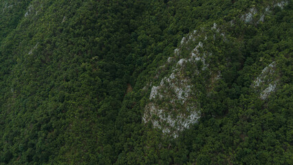 Close-up drone view of rocky outcrops covered in dense green forest on Ovcar mountain. Serbia...