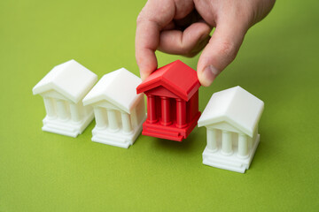 The hand places or removes the red bank among others. Liquidation of a bank due to lack of...
