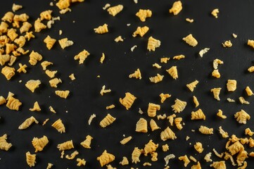 Fototapeta premium Golden Corn Flakes on Black Surface