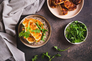 Delicious sandwich with fried halloumi and arugula on a plate on the table top view