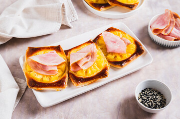 Pineapple and prosciutto tarts on a plate on a table
