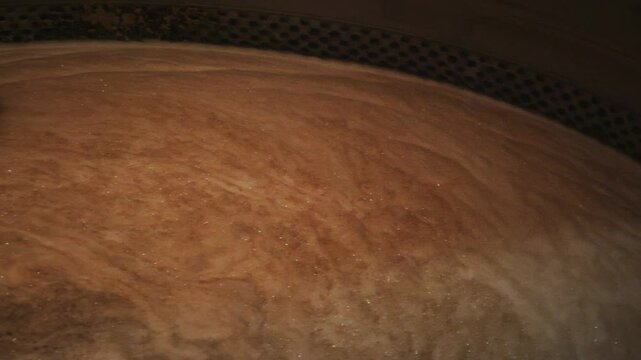 Wort, a sugary liquid extracted from malted grains, mixes in a large stainless steel tank during the beer brewing process in an industrial brewery