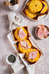 Pineapple and prosciutto tarts on a plate on a table top and vertical view