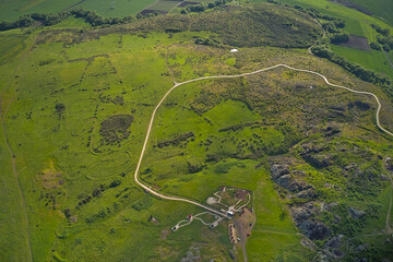 A winding mountain road — a serpentine path. A drone view of mountains, forest, and the road.
