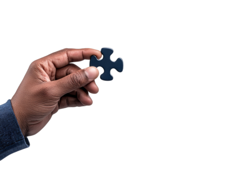 A Black male hand holding a blue puzzle piece against a simple black background.