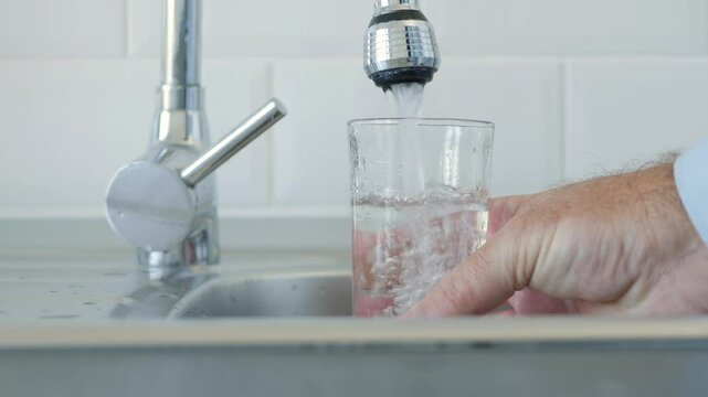 Thirsted Man Filling Up a Glass with Fresh Water from the Kitchen Water Tap.