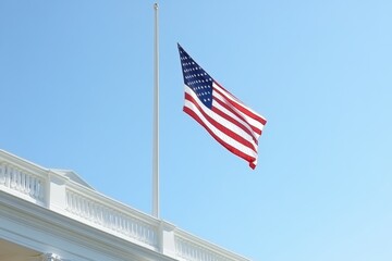 US flag displayed at half-mast against the backdrop of the White House during clear sky