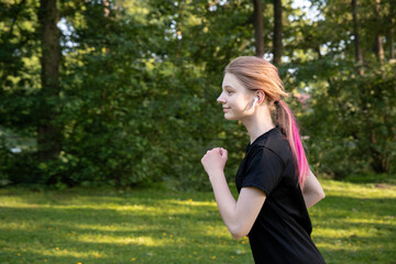 Teenager running energetically in a lush green park during morning light, showcasing determination...