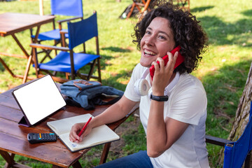 Digital nomad working remotely outdoors and making a phone call