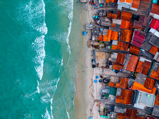 Aerial view of coastal vietnamese village with vibrant rooftops and turquoise sea