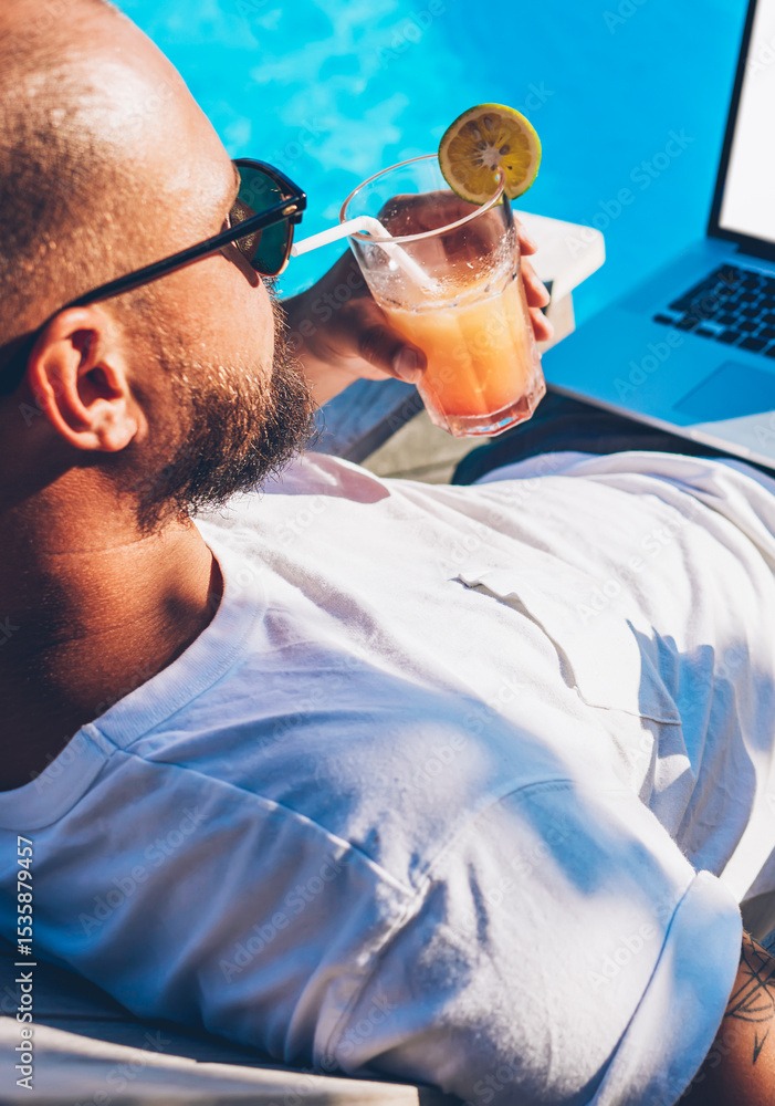 Poster young man checking email on smartphone and synchronizing media from phone on laptop with blank copy 